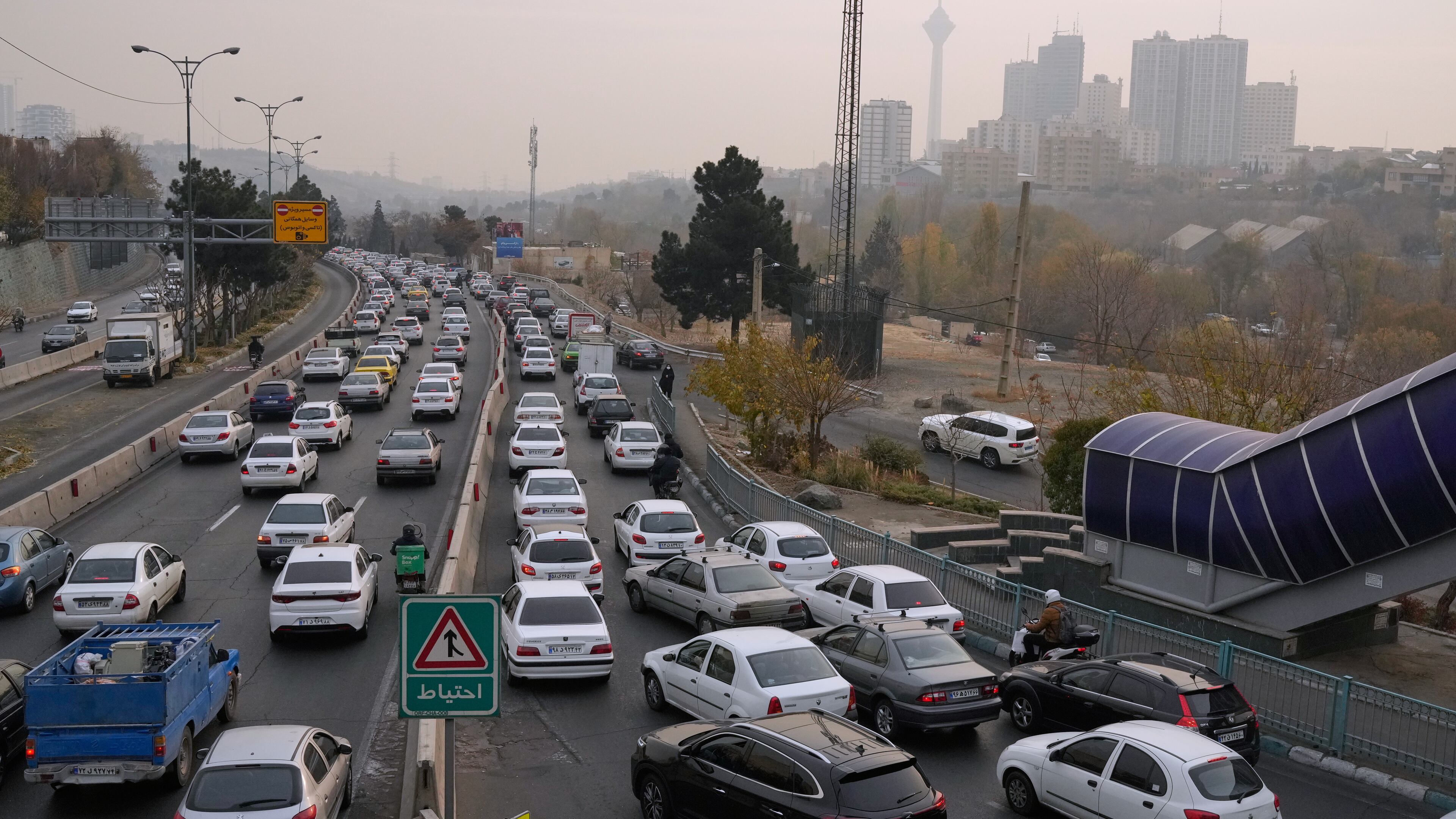 Cars drive in an afternoon traffic jam in a high air pollution in Tehran, Iran, Sunday, Dec. 7, 2025. (AP Photo/Vahid Salemi)
