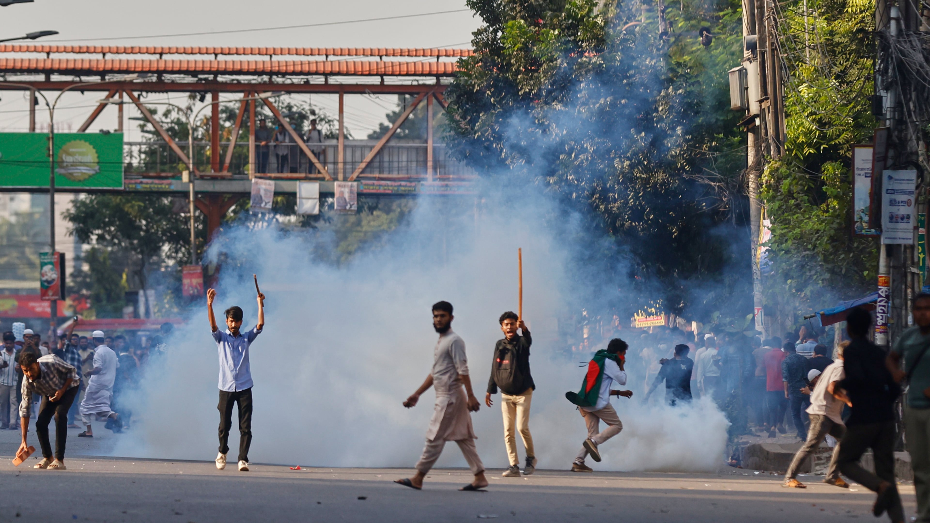 Protesters throw stones and shout slogans during a standoff with police outside the demolished residence of Sheikh Mujibur Rahman, Bangladesh's former leader and the father of the country's ousted Prime Minister Sheikh Hasina after the verdict against Hasina, in Dhaka, Bangladesh, Monday, Nov. 17, 2025. (AP Photo/ Rajib Dhar)