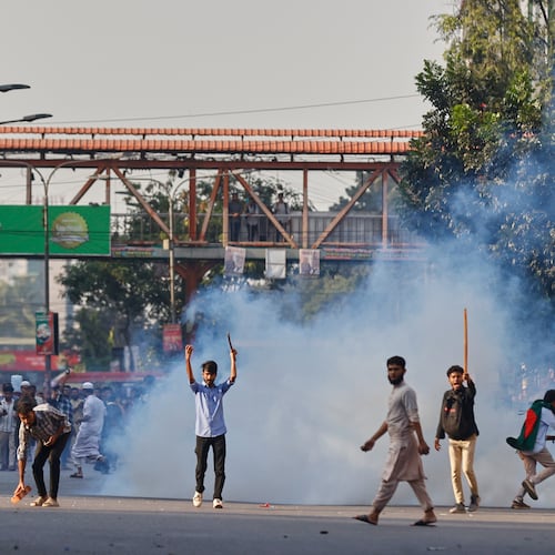 Protesters throw stones and shout slogans during a standoff with police outside the demolished residence of Sheikh Mujibur Rahman, Bangladesh's former leader and the father of the country's ousted Prime Minister Sheikh Hasina after the verdict against Hasina, in Dhaka, Bangladesh, Monday, Nov. 17, 2025. (AP Photo/ Rajib Dhar)