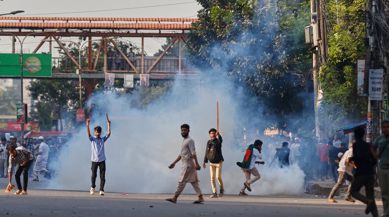 Protesters throw stones and shout slogans during a standoff with police outside the demolished residence of Sheikh Mujibur Rahman, Bangladesh's former leader and the father of the country's ousted Prime Minister Sheikh Hasina after the verdict against Hasina, in Dhaka, Bangladesh, Monday, Nov. 17, 2025. (AP Photo/ Rajib Dhar)