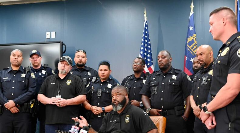 Officer Max Brewer (seated), surrounded by the Atlanta Police Department's motors unit, was seriously injured in May 2020 when he was hit by an ATV during the second night of protests following the death of George Floyd in Minnesota.