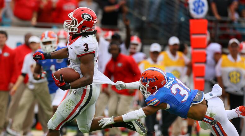 Georgia tailback Todd Gurley breaks away from Florida defensive back Cody Riggs who can't hold on to his jersey for a 70-yard plus touchdown run and a 14-0 lead during the first quarter on Saturday, Nov. 2, 2013, in Jacksonville.