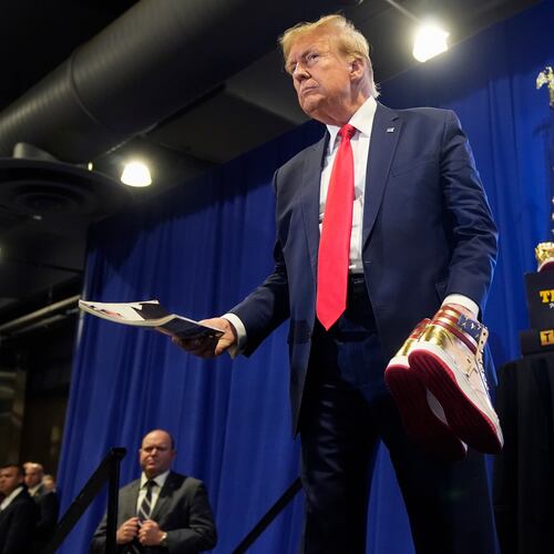 FILE - Donald Trump holds a Playboy magazine and gold Trump sneakers at Sneaker Con Philadelphia, an event popular among sneaker collectors, in Philadelphia, Feb. 17, 2024. (AP Photo/Manuel Balce Ceneta, File)