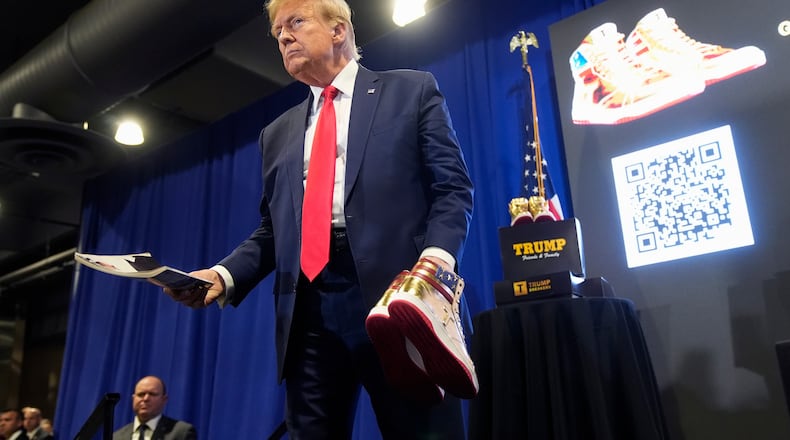FILE - Donald Trump holds a Playboy magazine and gold Trump sneakers at Sneaker Con Philadelphia, an event popular among sneaker collectors, in Philadelphia, Feb. 17, 2024. (AP Photo/Manuel Balce Ceneta, File)