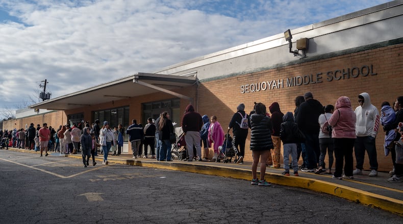 About 300 families line up outside Sequoyah Middle School to receive free food, clothes and COVID vaccines at a "holiday healing" event hosted by local non-profit WeLoveBufordHighway. Saturday, December 14, 2024 (Ben Hendren for the Atlanta Journal-Constitution)