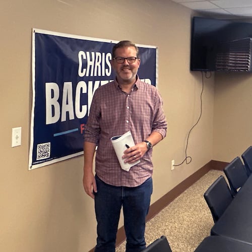 Democratic congressional candidate Chris Backemeyer poses in front of a campaign banner after an event in Murdock, Nebraska, on Sunday, Aug. 16, 2026. (AP Photo/Will Weissert)