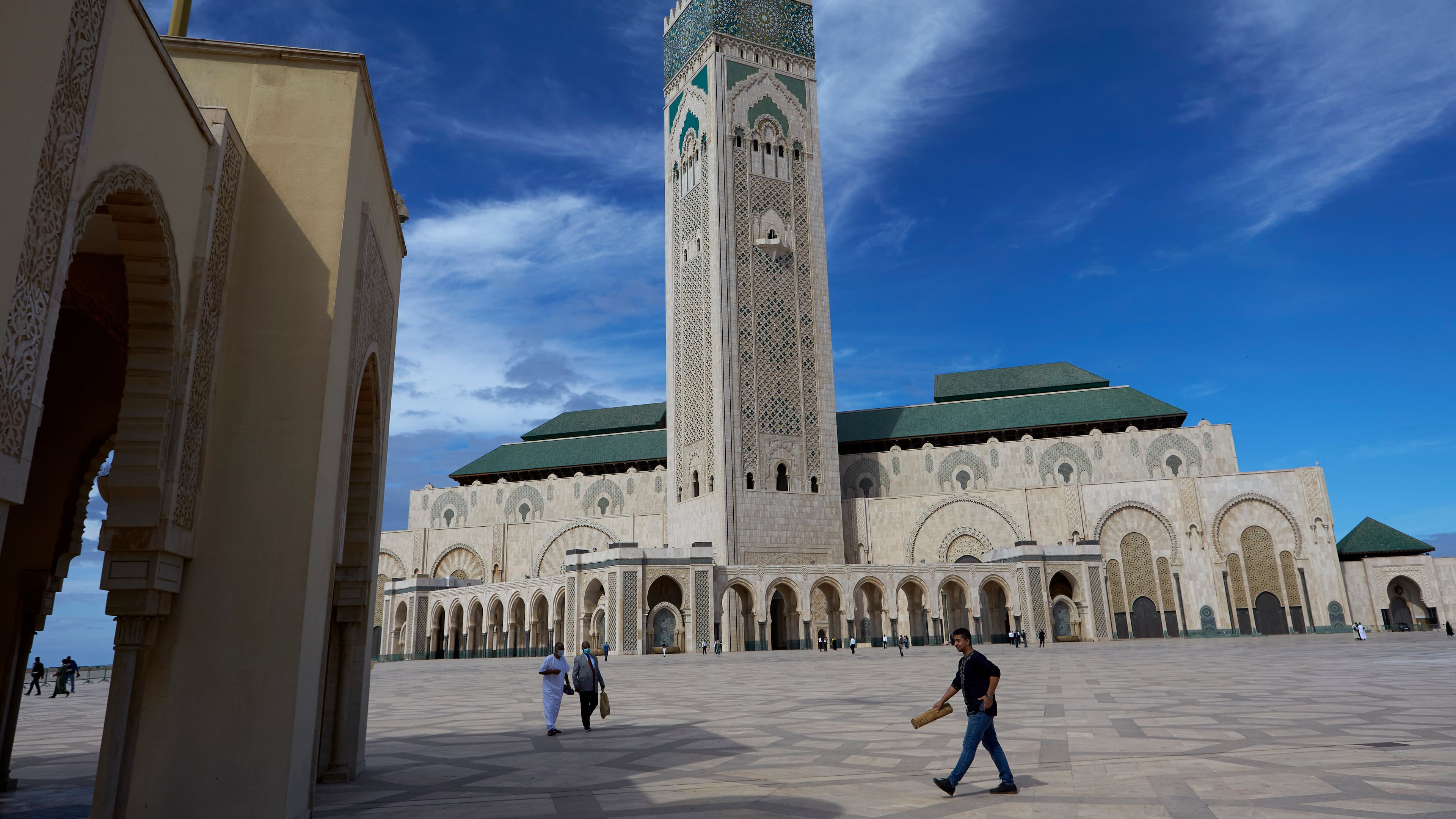 FILE - People walk past the great Hassan II Mosque in Casablanca, Morocco, Oct. 16, 2020. (AP Photo/Abdeljalil Bounhar, File)