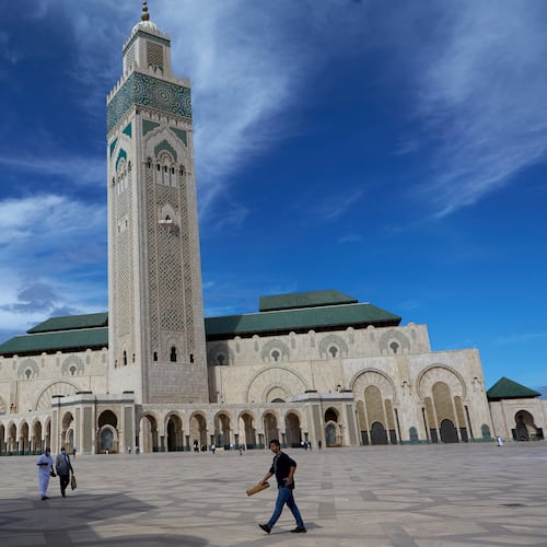 FILE - People walk past the great Hassan II Mosque in Casablanca, Morocco, Oct. 16, 2020. (AP Photo/Abdeljalil Bounhar, File)