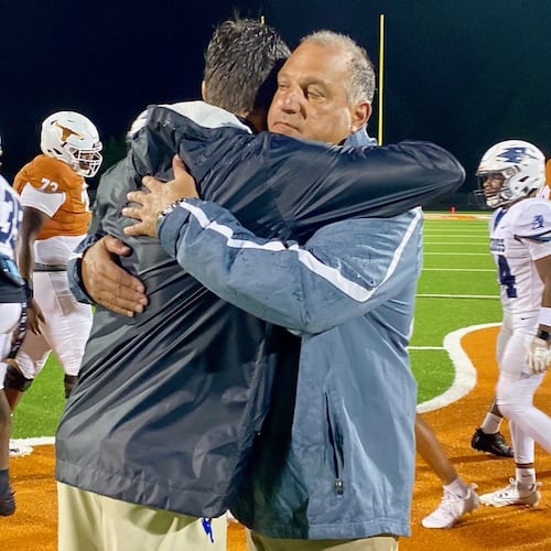 Norcross High coach Keith Maloof hugs his son Tyler Maloof, the coach at Lanier High, after the Blue Devils’ 31-10 win on Friday, Aug. 16, 2024. It was the first father-son coaching matchup in GHSA football since 2006. (Ken Sugiura/AJC 2024)