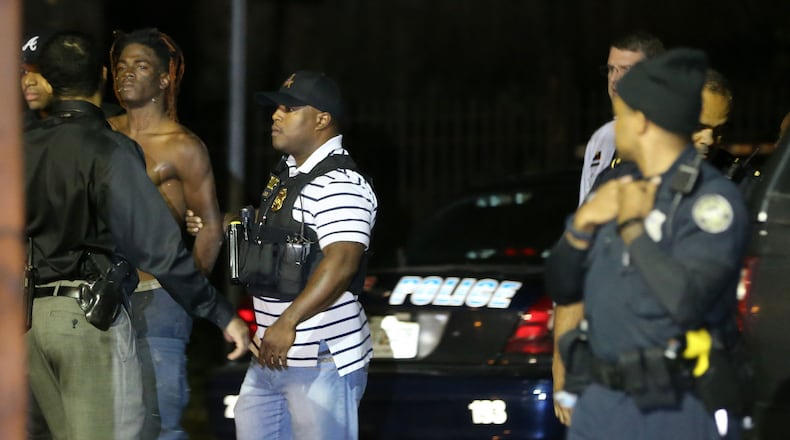Clifford Kirkland is led out of an apartment building by Atlanta police officers after the SWAT team arrested him on an outstanding warrant for aggravated assault Wednesday night, Oct. 28, 2015. (Ben Gray / bgray@ajc.com)