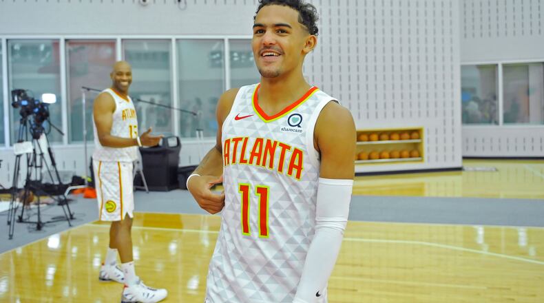 Hawks guard Trae Young smiles as he walks toward reporters after talking with forward Vince Carter (left) during the Atlanta Hawks Media Day Sept. 30, 2019, at Emory Sports Medicine Complex in Atlanta.