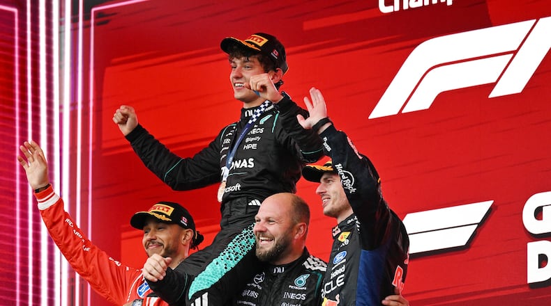First-place finisher Mercedes driver Kimi Antonelli, top, of Italy, is held aloft by second-place finisher Ferrari driver Lewis Hamilton, left, of Britain, and Mercedes senior composite technician Dean Hale, second from right, as third-place finisher Red Bull Racing driver Max Verstappen, right, of the Netherlands, joins them following the F1 Canadian Grand Prix auto race in Montreal, Sunday, May 24, 2026. (Graham Hughes/The Canadian Press via AP)