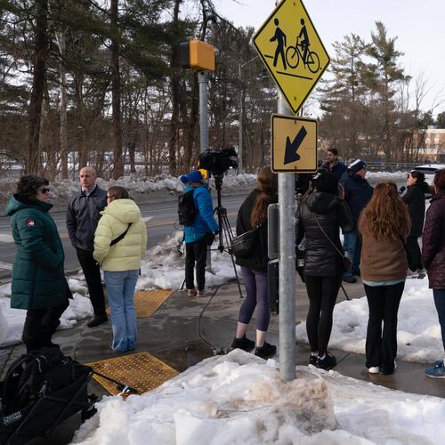 People wait outside Thomas S. Wootton High School for students in Rockville Md., Monday, Feb. 9, 2026, after a person was shot inside the school. (AP Photo/Jose Luis Magana)