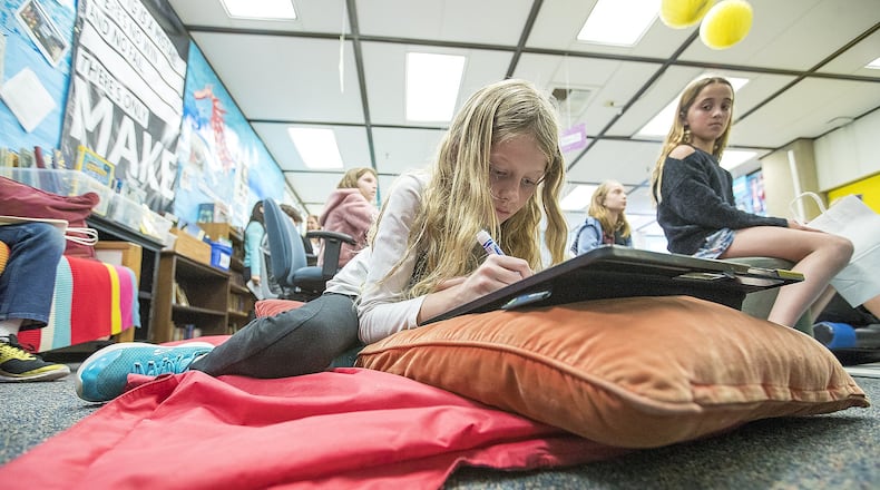 Amanda Garrett, 9, works on a project while lying on a mat during a fourth-grade class at Anderson Elementary School in Newport Beach, California. Contributed by Scott Smeltzer/Los Angeles Times/TNS