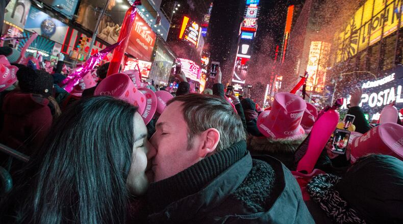 Chris and Chelsea Crawford, of Scotland, share a kiss at midnight in Times Square during a New Year's Eve celebration, Thursday, Jan. 1, 2015, in New York. Thousands braved the cold to watch the annual ball drop and ring in the new year. (AP Photo/John Minchillo)