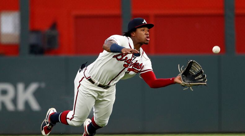 Atlanta Braves center fielder Ronald Acuna Jr. dives to catch a fly ball by Los Angeles Dodgers' Corey Seager with the bases loaded for the final out in the second inning of a baseball game Saturday, Aug. 17, 2019, in Atlanta. (AP Photo/John Bazemore)
