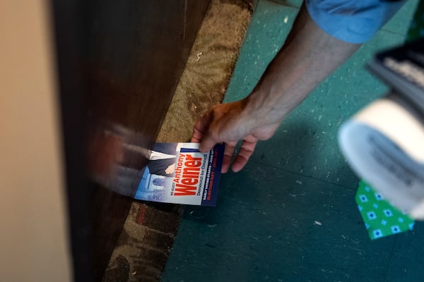 Anthony Weiner slides a campaign flyer under a resident's door while campaigning for a seat on the New York City Council, Thursday, May 29, 2025 in New York. (AP Photo/Angelina Katsanis)