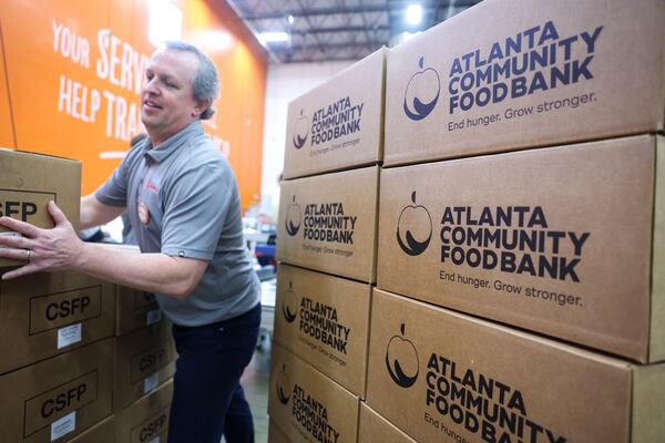 Justin Heineman, a partner at Kilpatrick Townsend & Stockton, stacks boxes of food donations as part of the Georgia Legal Food Frenzy at the Atlanta Community Food Bank in Atlanta on April 17, 2026. (Arvin Temkar/AJC)