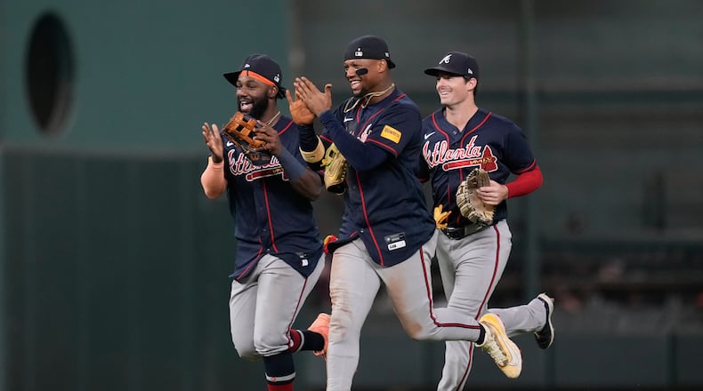 Atlanta Braves center fielder Michael Harris II, left, right fielder Ronald Acuña Jr., center, and left fielder Mike Yastrzemski celebrate after winning a baseball game against the Houston Astros in Houston, Saturday, Sept. 19, 2026. (AP Photo/Ashley Landis)