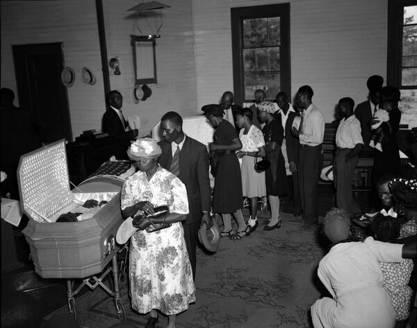 Moore's Ford Bridge mass lynching, July 25, 1946. Funeral services for African-American lynching victims George W. Dorsey and his sister Dorothy Dorsey Malcom. Mourners walking past the open coffin, Mount Perry Baptist Church, Bishop, Georgia, July 28, 1946. (The Atlanta Journal-Constitution Photographic Archives. Special Collections and Archives, Georgia State University Library.)