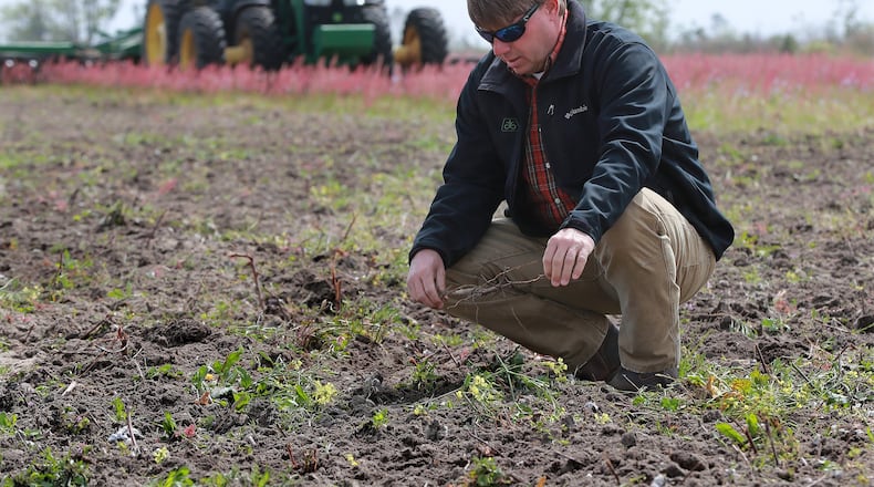 Justin Jones looks over one of his cotton fields being prepared for spring planting earlier this year on his 3,000-acre farm in Albany. Many Georgia farmers faced depressed commodity prices and damage from Hurricane Michael last year. Now, some are wrestling with risks posed by China’s decision to halt imports of U.S. agricultural products. Curtis Compton/ccompton@ajc.com