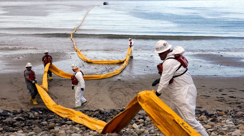 FILE - Workers prepare an oil containment boom at Refugio State Beach, north of Goleta, Calif., on May 21, 2015, two days after an oil pipeline ruptured, polluting beaches and killing hundreds of birds and marine mammals. (AP Photo/Jae C. Hong, File)