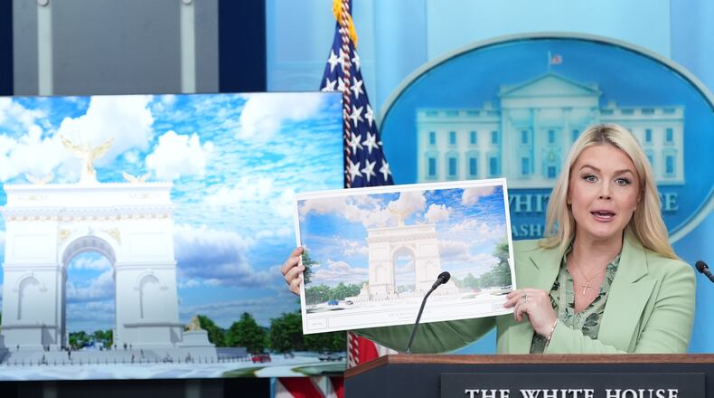 White House press secretary Karoline Leavitt holds up an artist rendering of the new triumphal arch as she speaks with reporters in the James Brady Press Briefing Room at the White House, Wednesday, April 15, 2026, in Washington. (AP Photo/Alex Brandon)