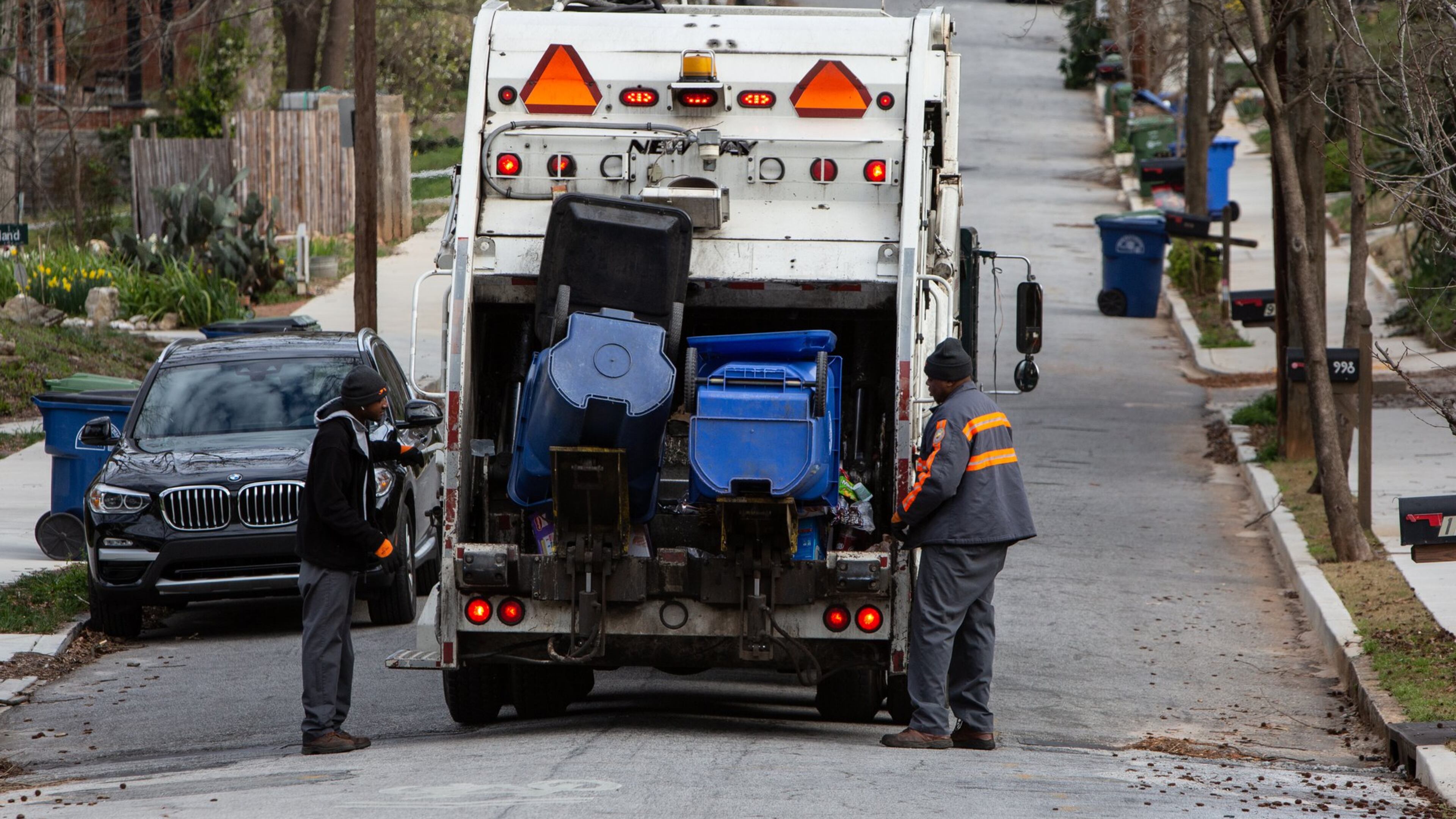 Sean Johnson (left) and Mike Reed picked up recycling bins for the city of Atlanta in the Ormewood Park area in 2019. An audit of the city’s recycling program found that Atlanta residents send more waste to landfills than the national average. (Phil Skinner/AJC)