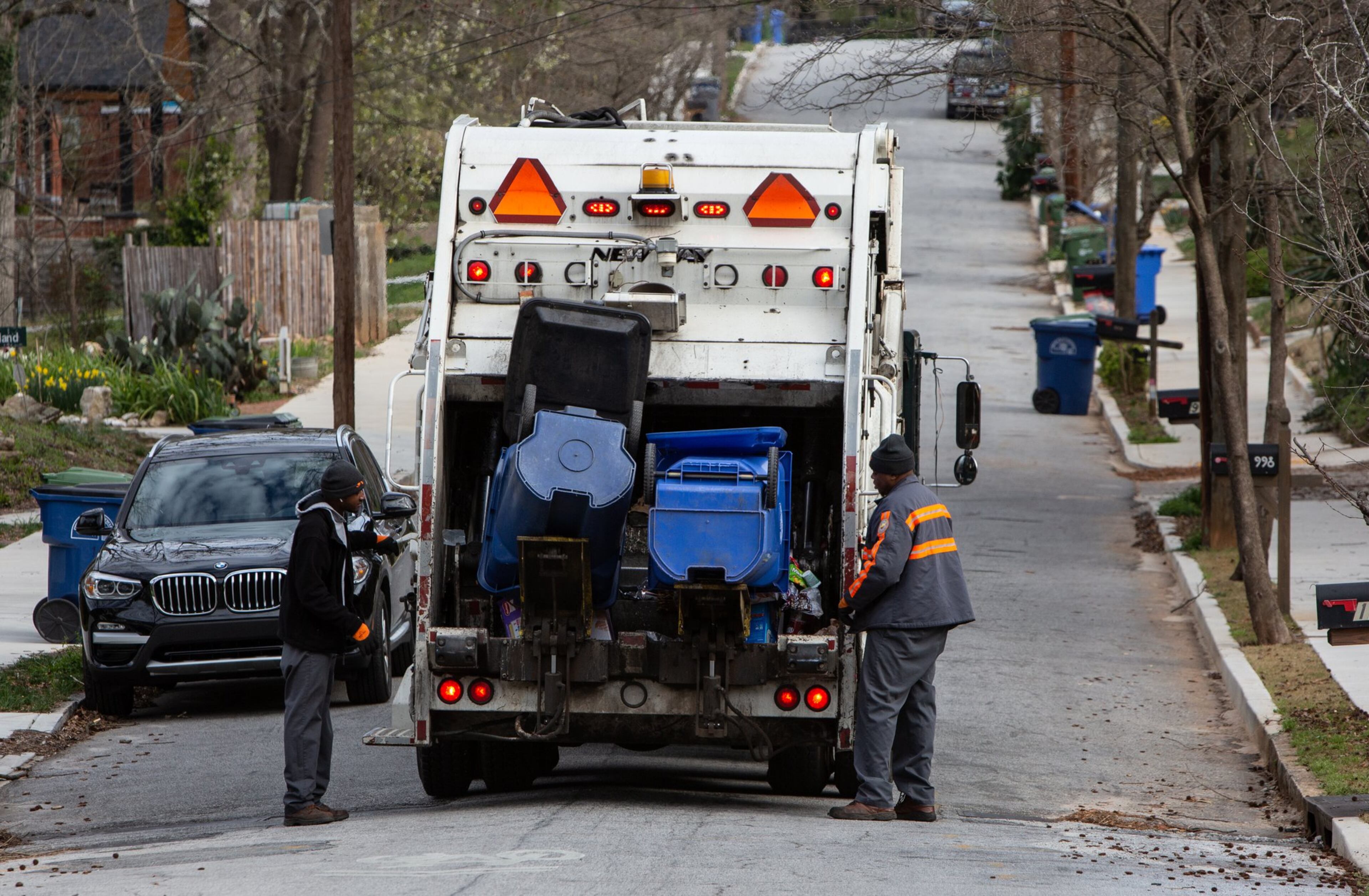Sean Johnson (left) and Mike Reed load recycling bins in the Ormewood Park area on March 7, 2019. An education program started in 2017 has seen recycling rates double in Atlanta. (Phil Skinner/AJC)