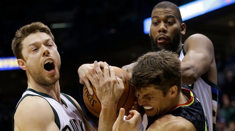 Atlanta Hawks’ Kyle Korver, middle, is defended by Milwaukee Bucks’ Matthew Dellavedova, left, and Greg Monroe, right, during the second half of an NBA basketball game Friday, Dec. 9, 2016, in Milwaukee. The Hawks won 114-110. (AP Photo/Aaron Gash)