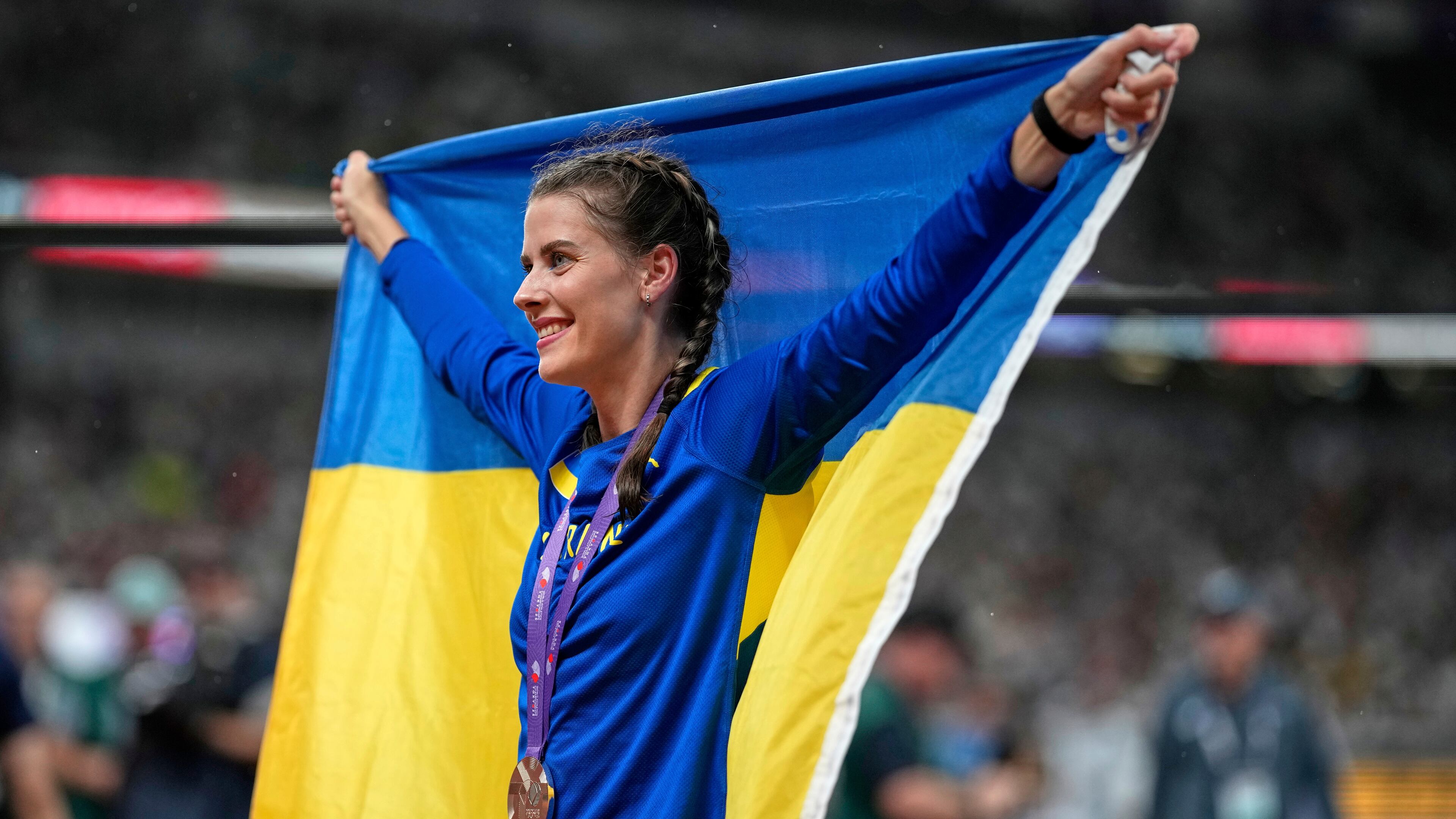 Ukraine's Yaroslava Mahuchikh celebrates taking the bronze in the women's high jump final at the World Athletics Championships in Tokyo, Sunday, Sept. 21, 2025. (AP Photo/Louise Delmotte)