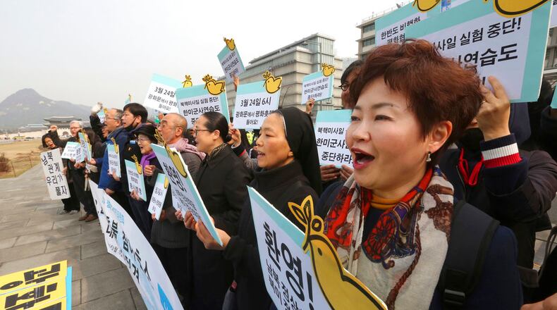 Protesters stage a rally demanding peace on the Korean Peninsula near U.S. Embassy in Seoul, South Korea, Monday, March 12, 2018. Trump administration officials said Sunday there will be no more conditions imposed on North Korea before a first-ever meeting of the two nation's leaders beyond the North's promise not to resume nuclear testing and missile flights or publicly criticize U.S.-South Korean military exercises. The signs read: "Welcome planned summits between North Korea and the United States, South Korea and North Korea." (AP Photo/Ahn Young-joon)