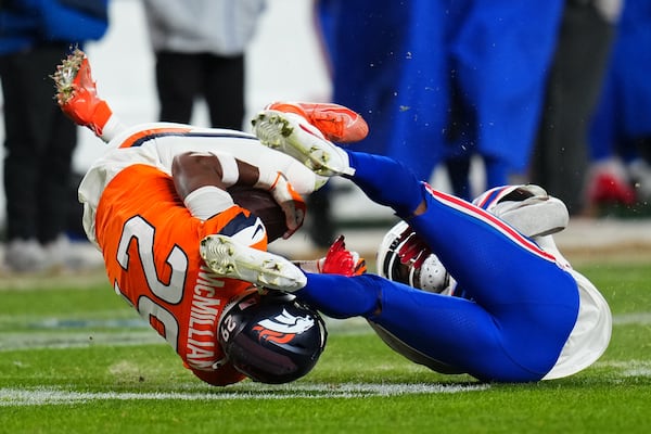 Denver Broncos cornerback Ja'quan McMillian (left) wrangles an overtime pass intended for Buffalo Bills wide receiver Brandin Cooks.
