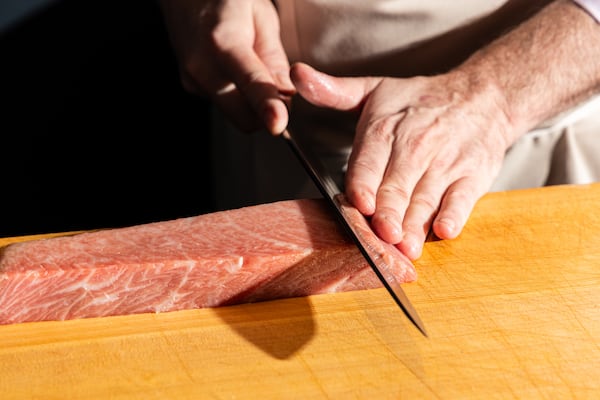 Chef J. Trent Harris, James Beard finalist and Executive Chef at Mujō, begins the process of descaling and deboning fish before service at the restaurant on June 5, 2026. (Cameren Rogers for the AJC)