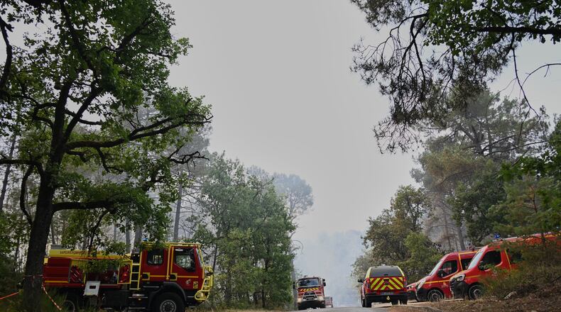 Fire trucks are parked near the scene of a wildfire in the region of the historic Fontainebleau forest, about 60 km (37 miles) south of Paris, France, Monday, July 13, 2026. (AP Photo/Emma Da Silva)