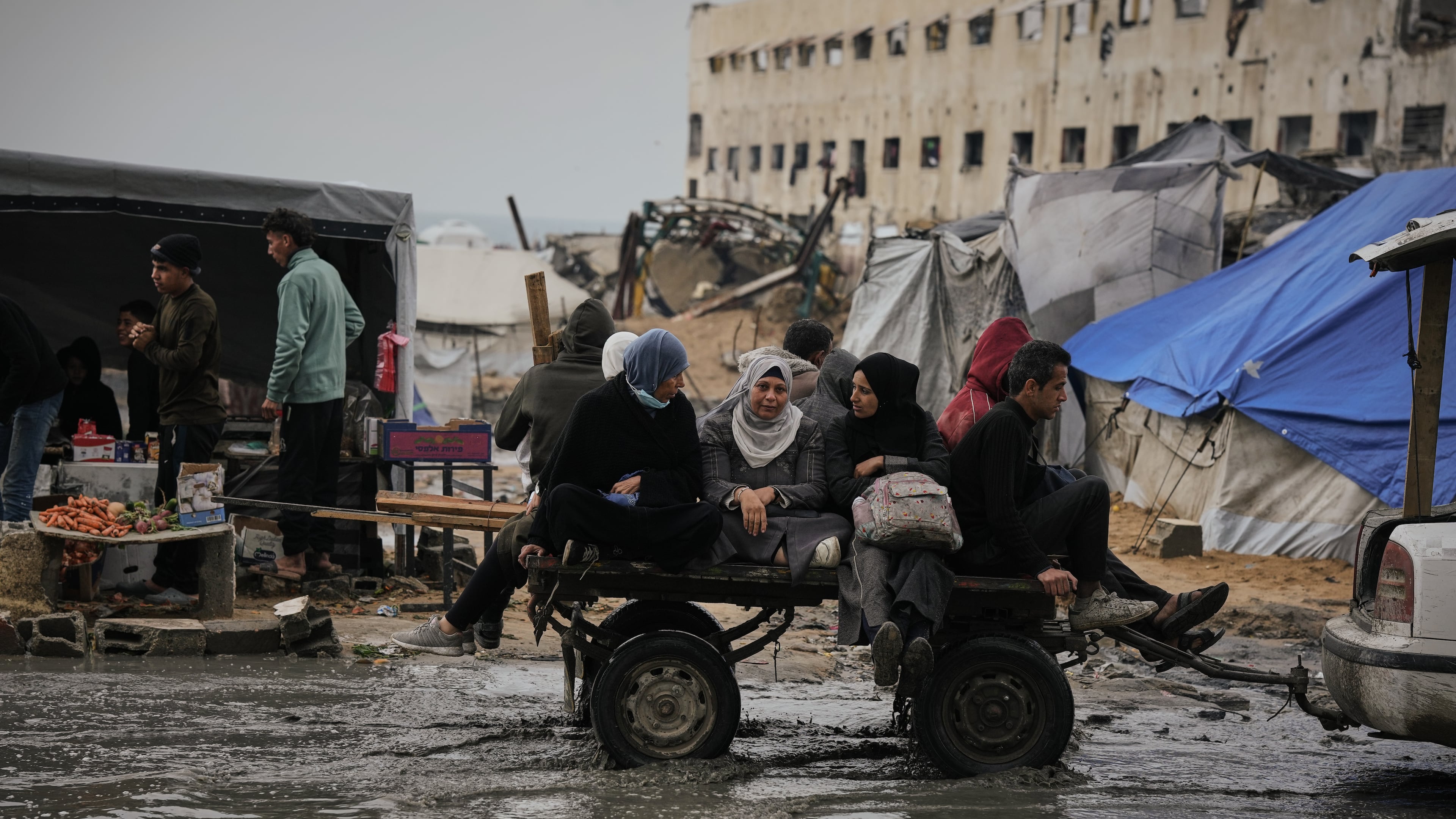 Palestinians ride in a cart pulled by a vehicle through a flooded street after stormy weather in Gaza City Wednesday, Dec. 10, 2025. (AP Photo/Jehad Alshrafi)