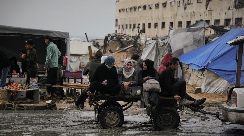 Palestinians ride in a cart pulled by a vehicle through a flooded street after stormy weather in Gaza City Wednesday, Dec. 10, 2025. (AP Photo/Jehad Alshrafi)