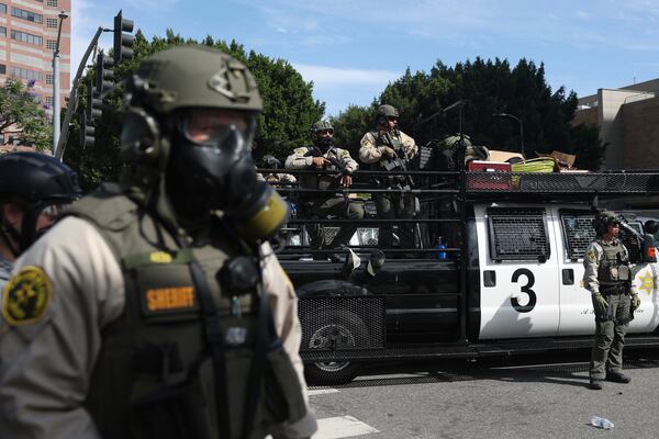 Law enforcement officers stand guard during a protest Saturday, June 14, 2025, in Los Angeles. (AP Photo/Ethan Swope)