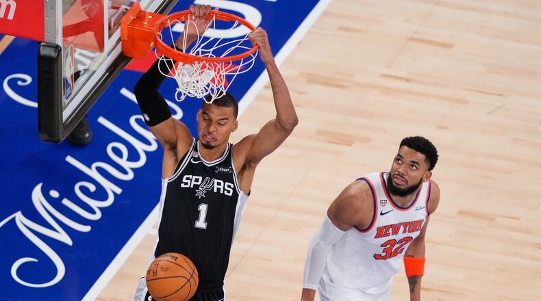 San Antonio Spurs forward Victor Wembanyama (1) dunks as New York Knicks center Karl-Anthony Towns (32) looks on during the second half of Game 3 of the NBA Finals basketball series, Monday, June 8, 2026, in New York. (AP Photo/Yuki Iwamura)