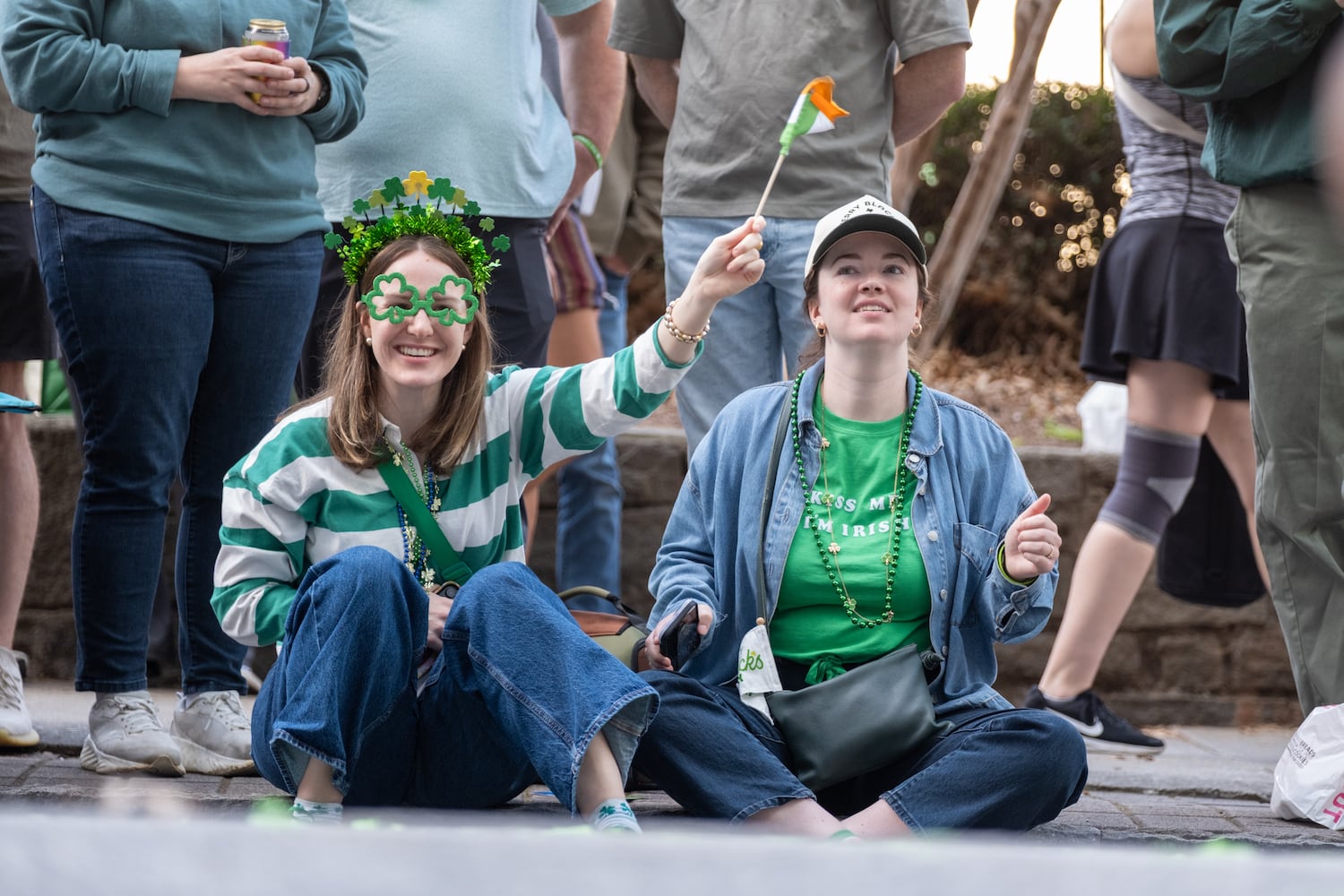Sisters Maggie and Lydia O’Brien watch the Atlanta St. Patrick’s Parade makes its way down Peachtree Street on Saturday, March 14, 2026. (Ben Gray for the AJC)
