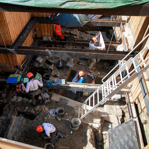 Archaeological workers wearing hard hats dig 4 meters (13 feet) underground during excavations outside Notre-Dame Cathedral in Paris, Monday, June 1, 2026. (AP Photo/Nicolas Garriga)