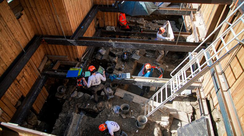 Archaeological workers wearing hard hats dig 4 meters (13 feet) underground during excavations outside Notre-Dame Cathedral in Paris, Monday, June 1, 2026. (AP Photo/Nicolas Garriga)