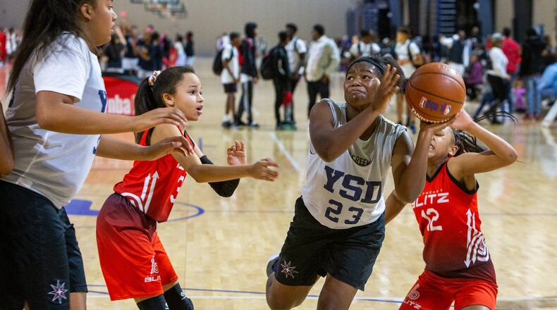 Team Impact’s Oddyssey Murray (center) tries to break through Blitz’s defense for a score during the Atlanta Hawks Youth Classic at the LakePoint Champions Center. Photo by Phil Skinner