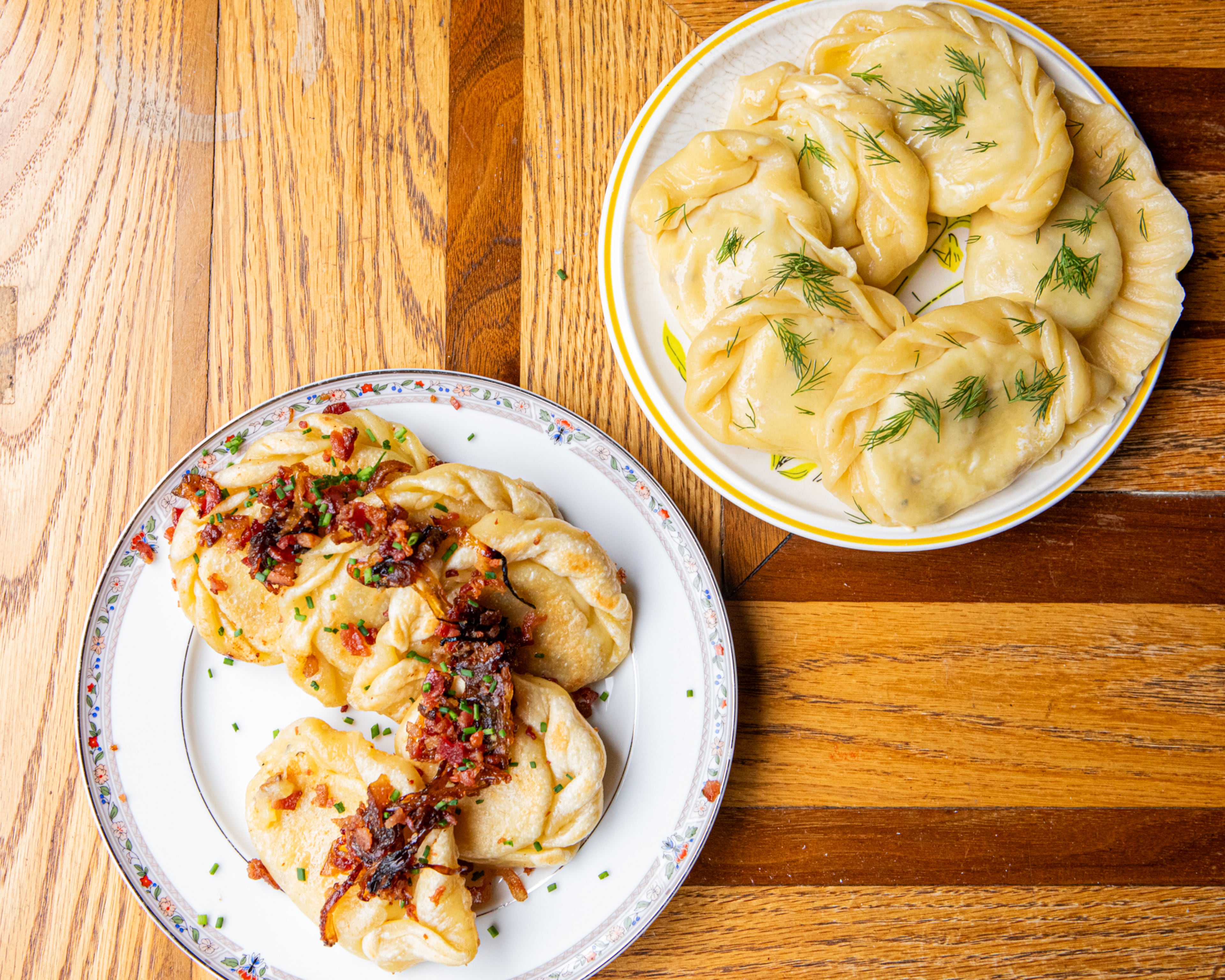 Basia Piechoczek serves her pierogi two ways: pan fried with bacon crumbles and crispy onions (left) or tossed in butter and garnished with chives (right). But she always serves pierogi with a side of sour cream. (Aaliyah Man for the AJC)