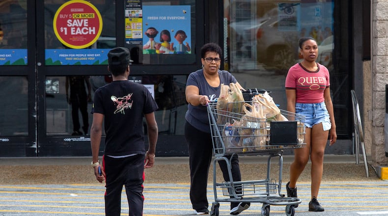 Tyana Baker (right) and her mother, Theresa Baker, head to their car after picking up groceries at a Kroger in Stone Mountain. The grocery giant recently met with customers of the Kroger store on Metropolitan Parkway to discuss concerns about the condition of the store. STEVE SCHAEFER / SPECIAL TO THE AJC