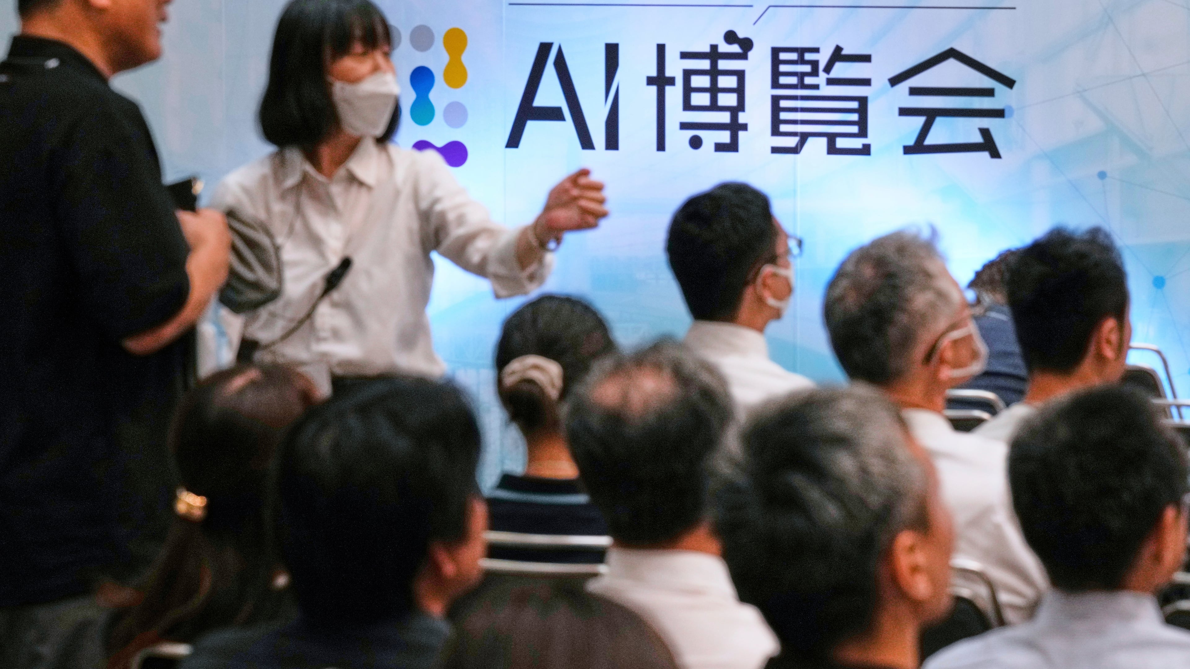 FILE - An usher directs an attendee to a seat for a seminar at a convention titled AI Expo in Tokyo, on Aug. 27, 2025. (AP Photo/Hiro Komae, File)