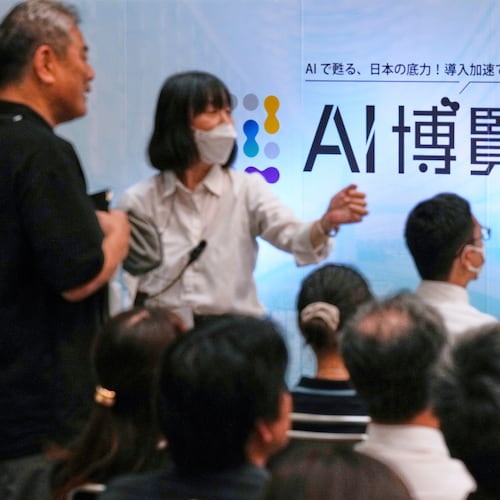 FILE - An usher directs an attendee to a seat for a seminar at a convention titled AI Expo in Tokyo, on Aug. 27, 2025. (AP Photo/Hiro Komae, File)