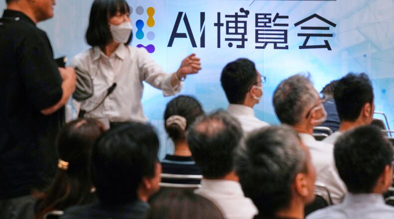 FILE - An usher directs an attendee to a seat for a seminar at a convention titled AI Expo in Tokyo, on Aug. 27, 2025. (AP Photo/Hiro Komae, File)