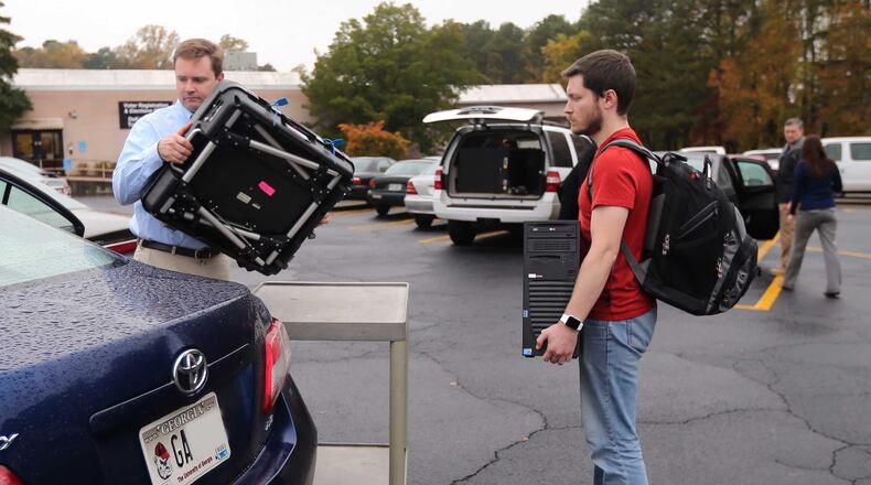 Investigators take a voting machine and a desktop computer from the DeKalb County elections office on Nov. 5, 2015. Ben Gray / bgray@ajc.com
