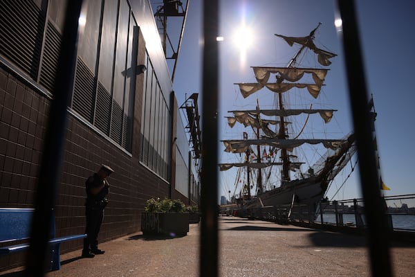 A New York Police officer stands watch on Pier 35 where the Cuauhtémoc, a masted Mexican Navy training ship that collided with the Brooklyn Bridge the night before, sits docked. (AP Photo/Yuki Iwamura)